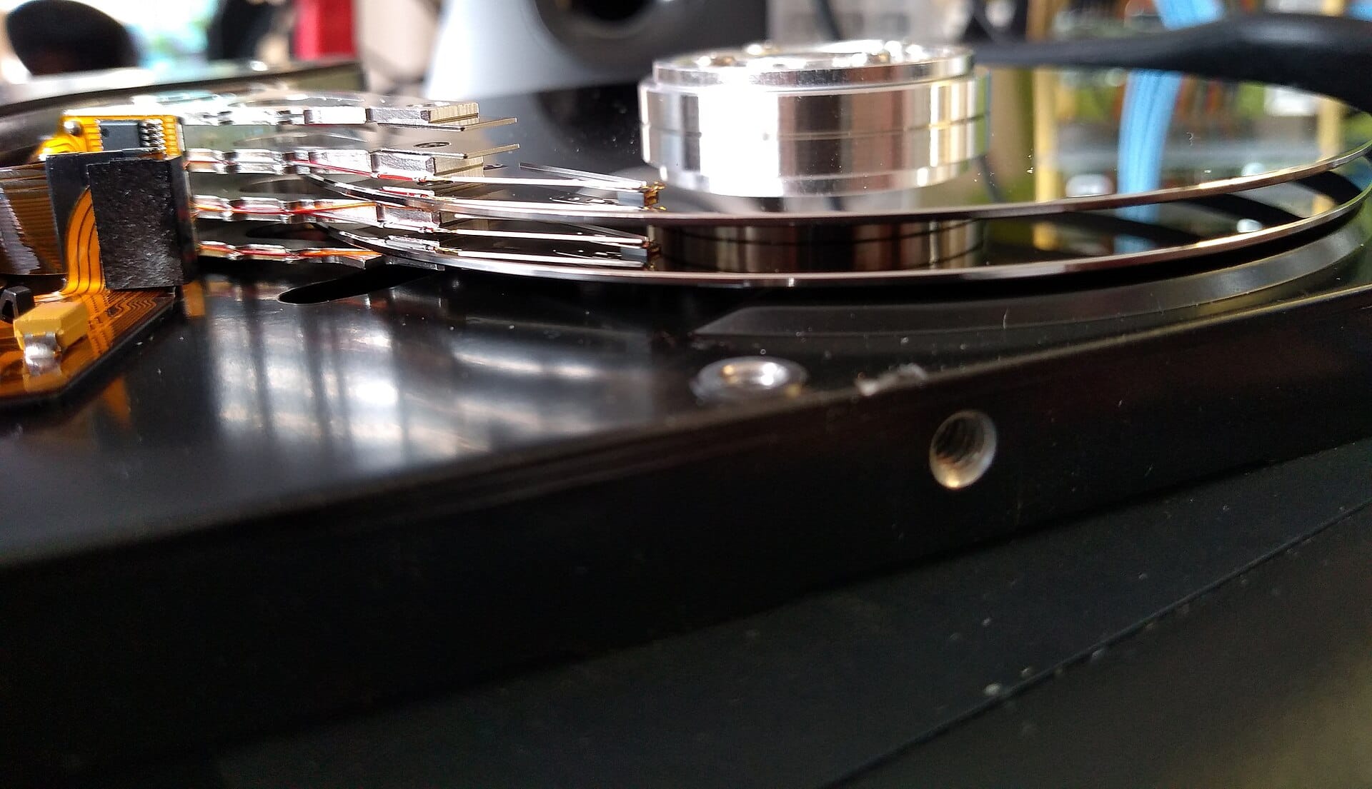 Open hard disk drive showing its platter and read/write head, the storage behind a SQL database