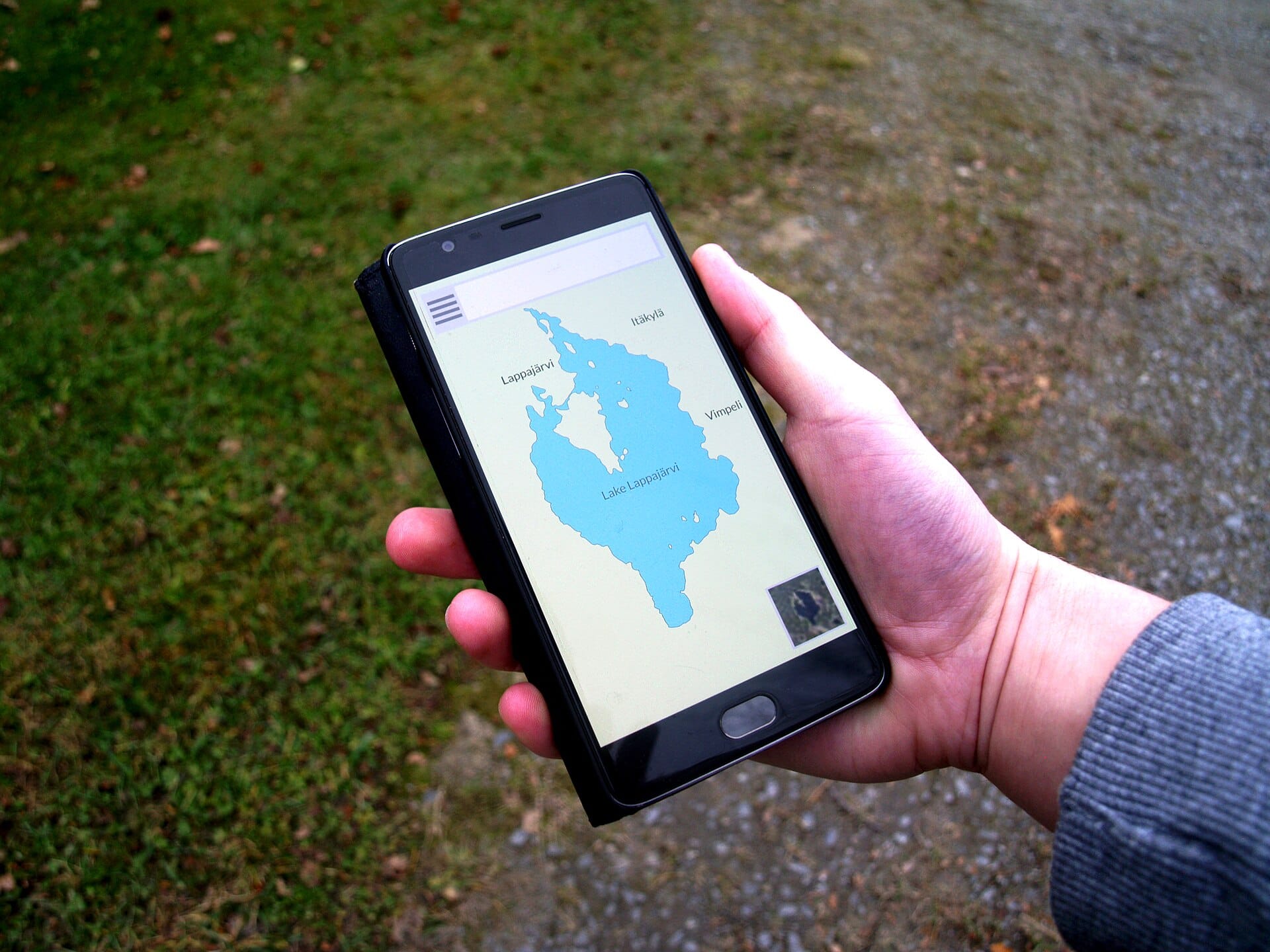 Hand holding a smartphone showing a map app, a device that reveals your location for online tracking