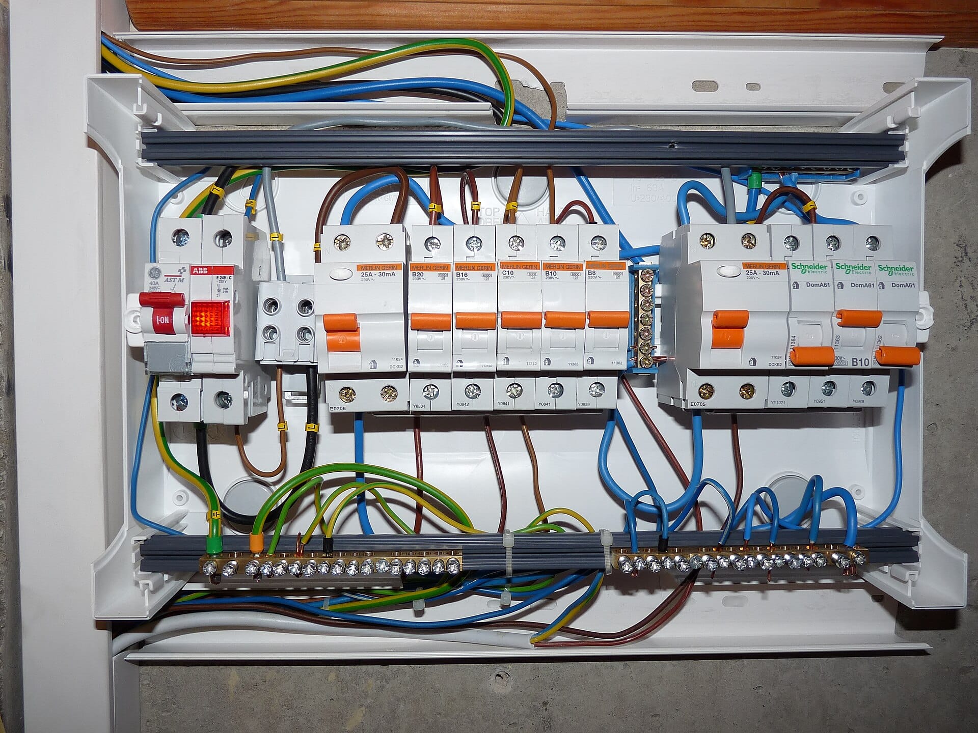 Open consumer unit with miniature circuit breakers, RCDs and earth/neutral bars, wiring clipped inside the enclosure