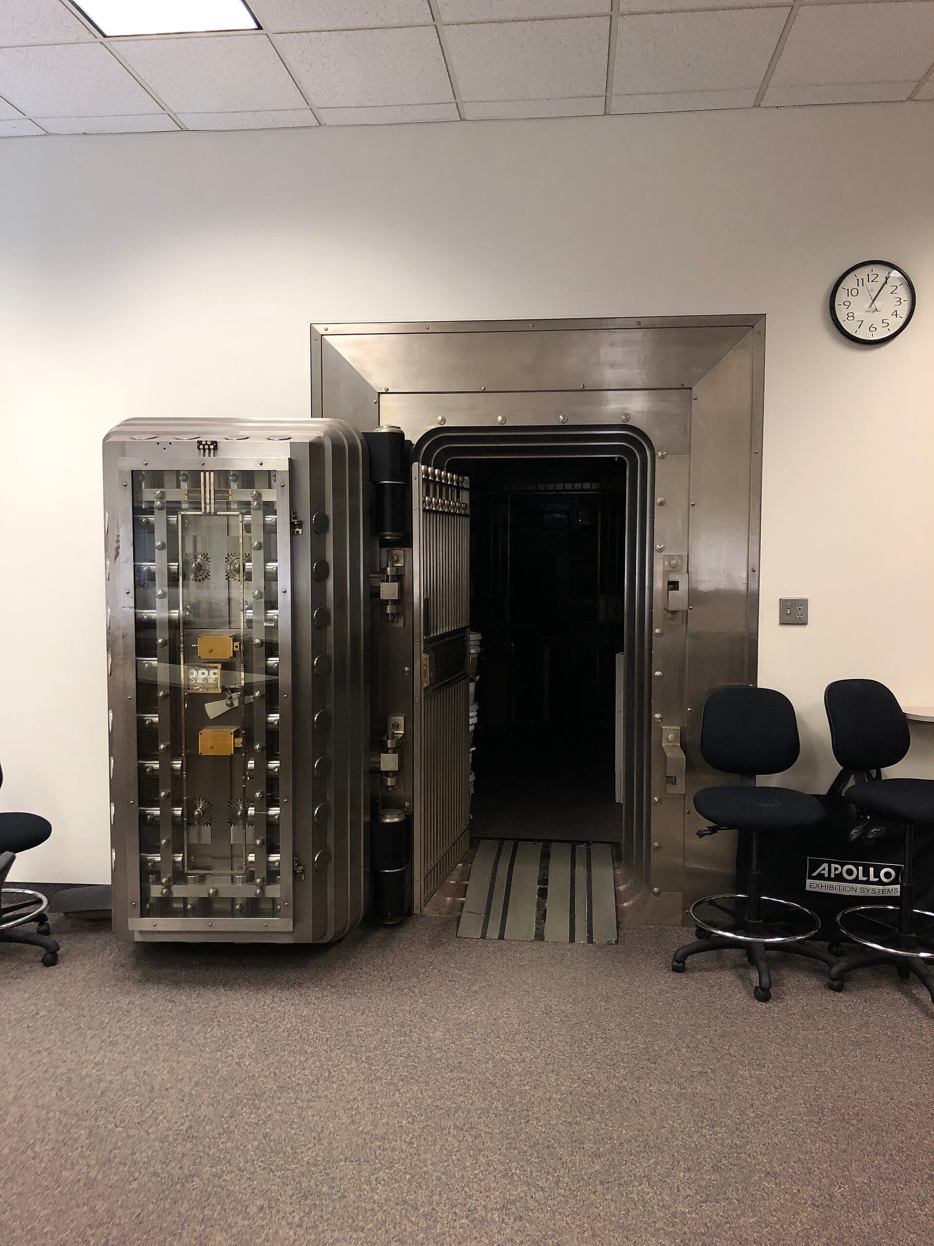 A heavy steel bank vault door standing open in a strongroom