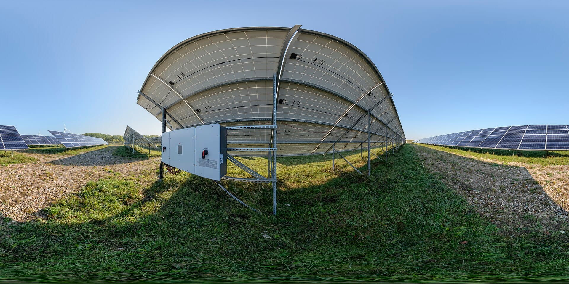 Central solar inverter cabinet mounted on the frame of a panel tracker in a ground-mounted PV field
