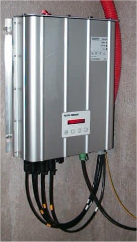 Wall-mounted solar inverter with thick power cables running from its base