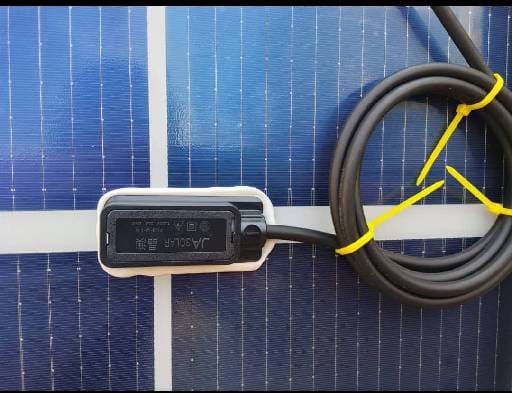 700W Solar Panel 1 Solar panel with a black power optimiser module and coiled cabling