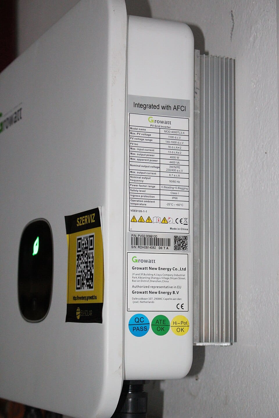 Growatt hybrid inverter on a wall with its specification label and green status light visible
