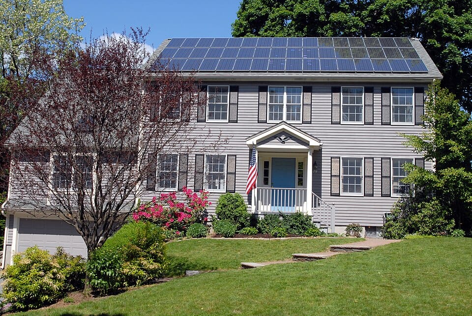 Two-storey house with a full-width solar panel array covering its pitched roof